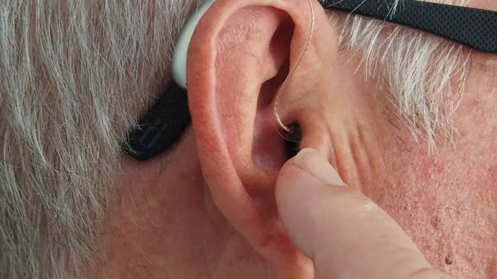 Close-up of an older adult's ear with a hearing aid