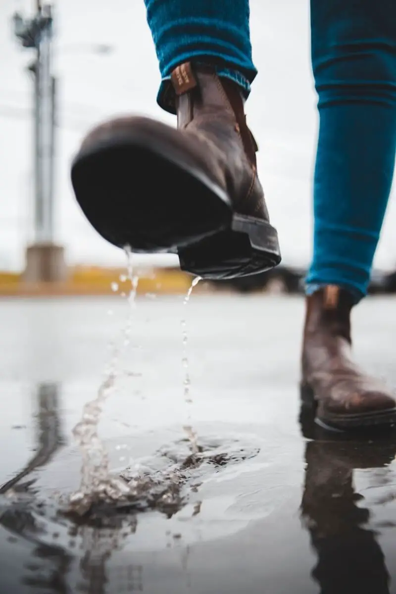 Close up of boots stomping through rain puddles.