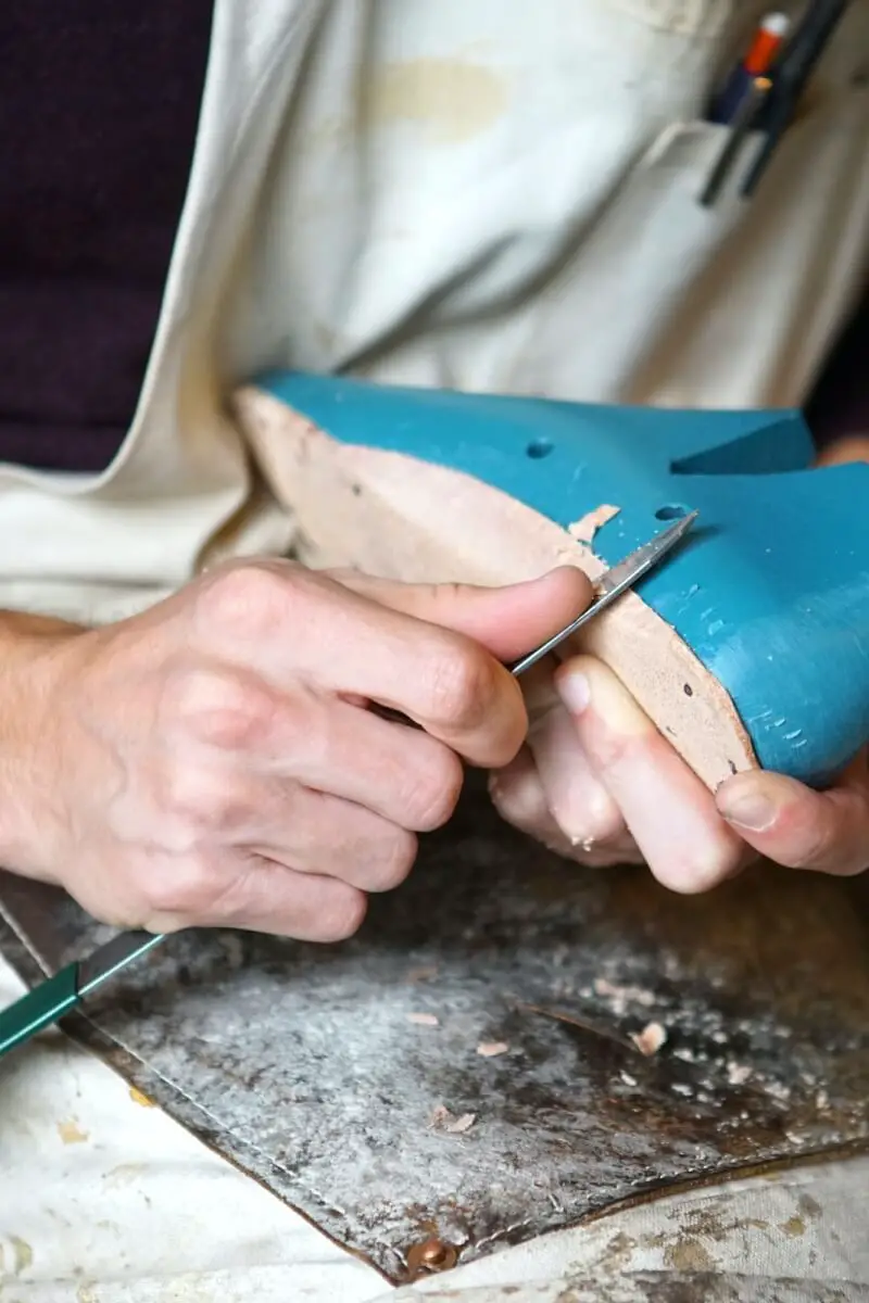 an artisan carving an insole to help treat a foot condition for elderly men