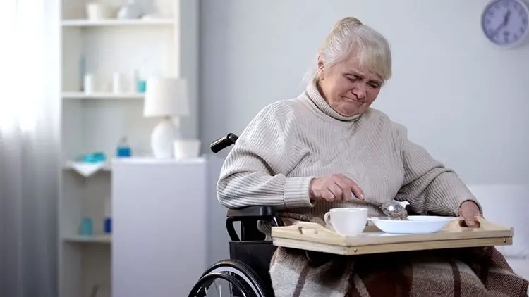 elderly woman eating on wheelchair