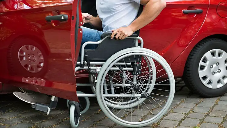 man on wheelchair boarding in car