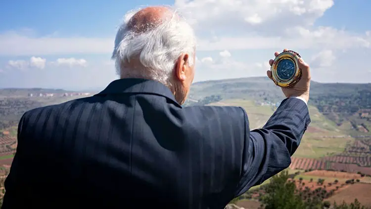 senior businessman holding a compass