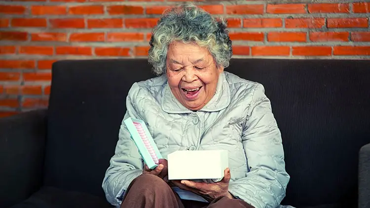 80-year-old woman opening a gift