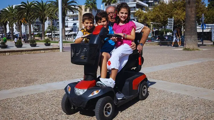 grandfather with grandchildren on mobility scooter