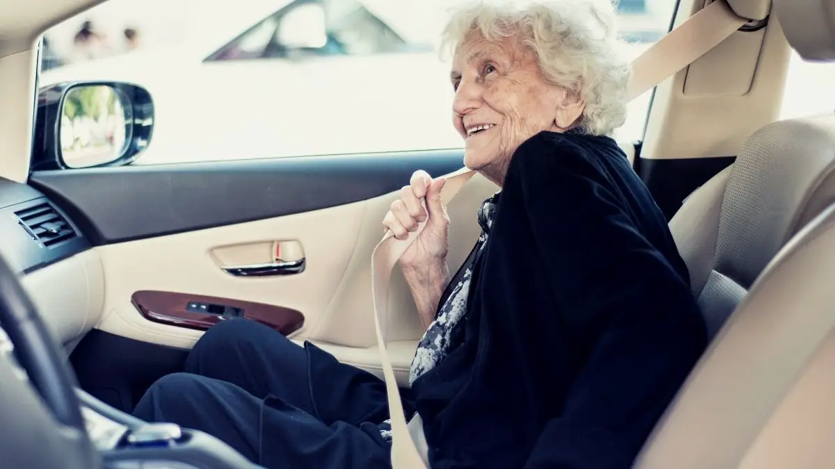 adult booster seats for seniors feature image - senior woman sitting on a chair pad to increase comfort and ensure good posture and the perfect height while sitting in a car