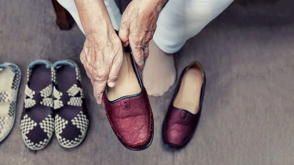 old woman putting on shoes