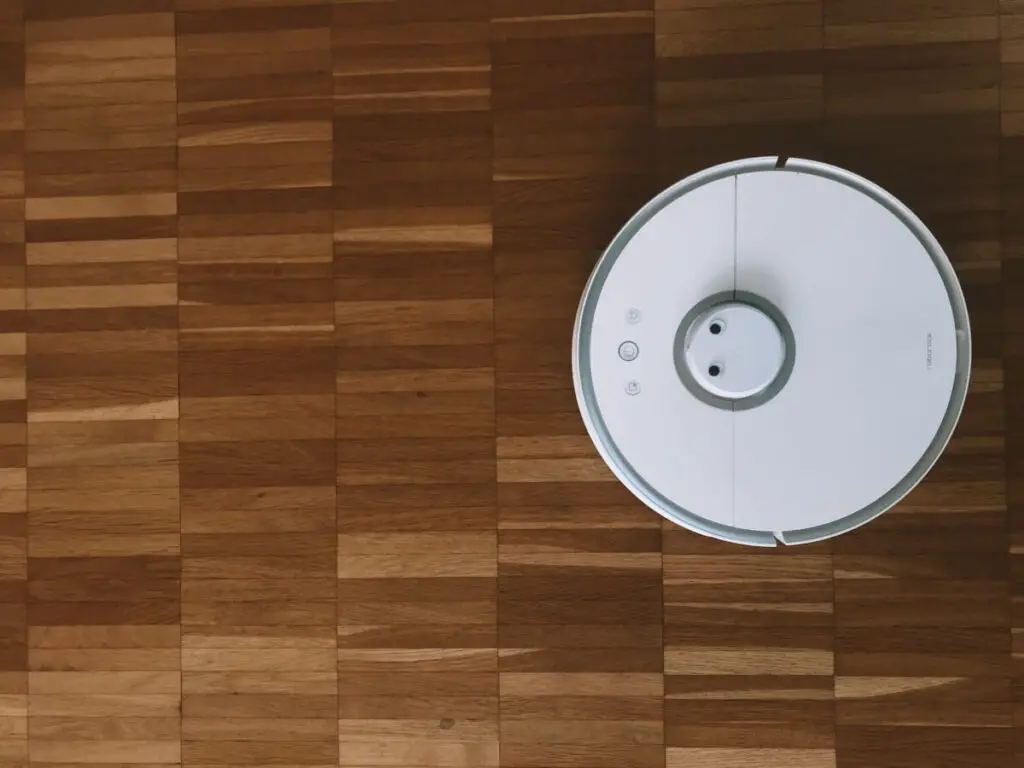 A white robot, cordless vacuum cleaner on hardwood floors - one of the easiest vacuum options on the market with deep cleaning power. 