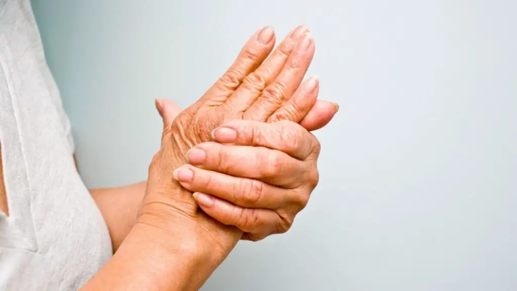 senior woman holding her arthritic hands