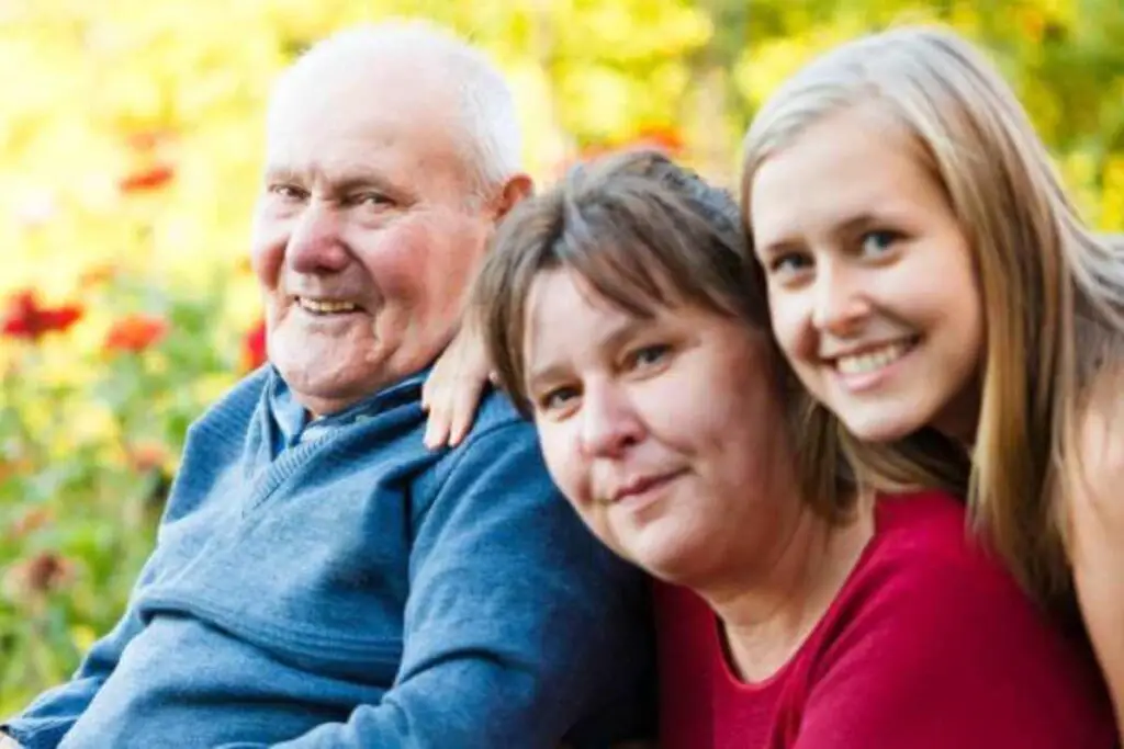 a memory care center patient spending time outside in a positive environment with his loved ones