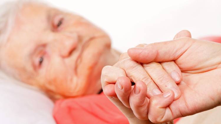 caregiver holding dementia patients hand