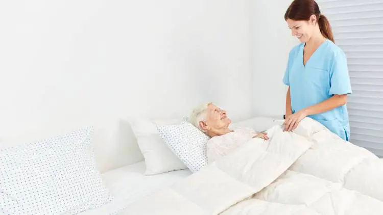geriatric nurse taking care of senior woman