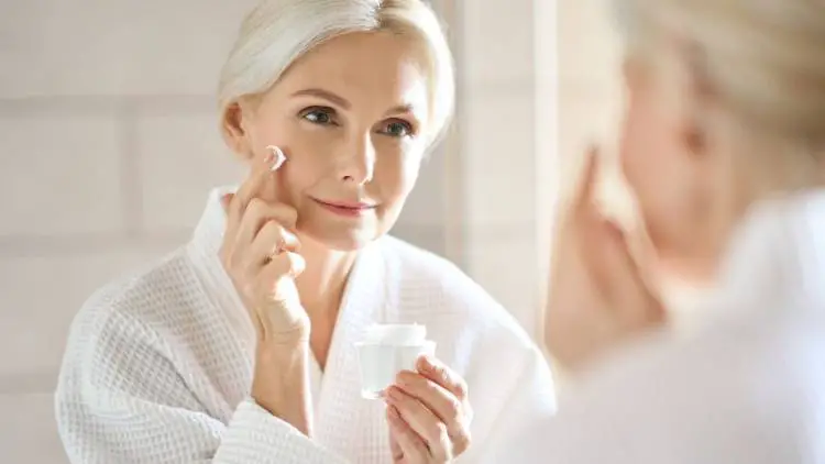 mid age woman applying moisturizer