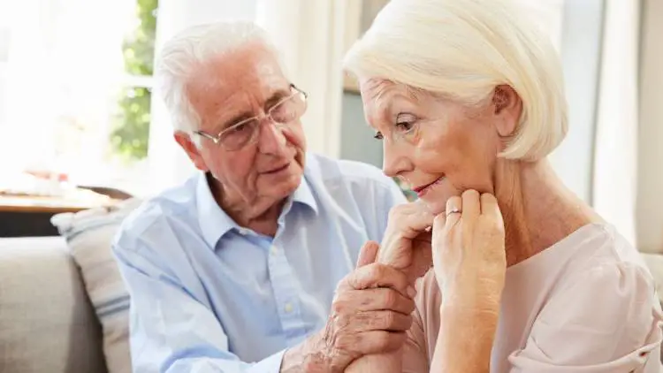 senior man comforting woman with dementia