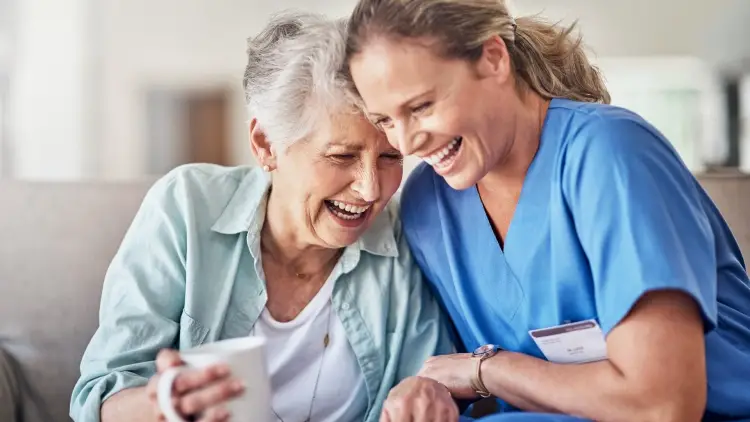 caregiver and elderly patient lauging