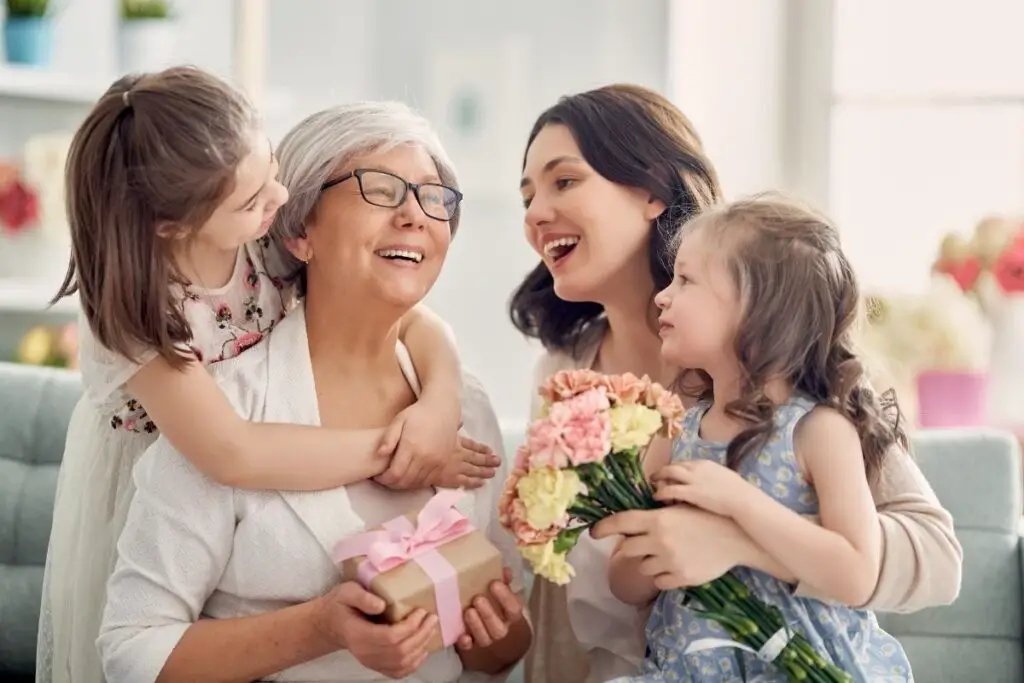 childrens giving mother's day gift to grandma