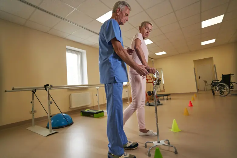 physical therapists helps a woman with a quad cane