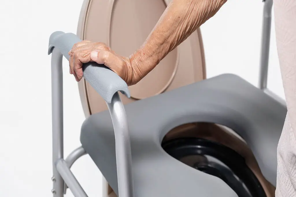 elderly woman using a toilet seat riser