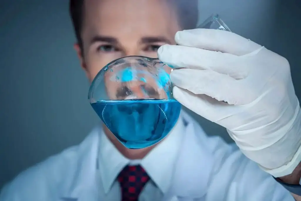 Chemist holding a flask with a blue substance 