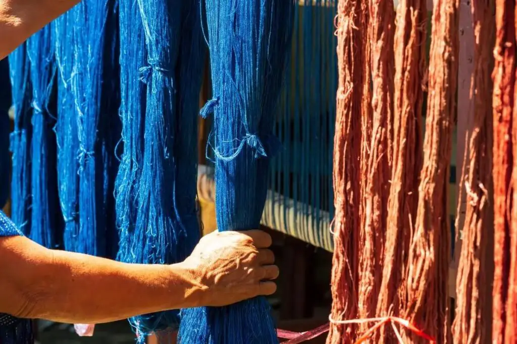 Hand holding yarn died blue, one of the original methylene blue uses 