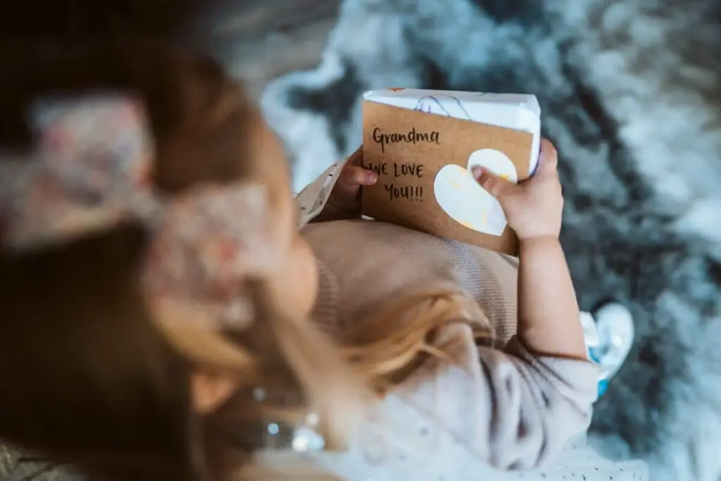 a young child holding a book of memories in honor of her grandmother who passed away