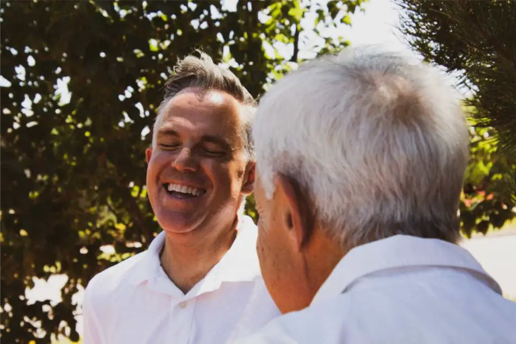 caring for aging parents checklist - aging in place checklist feature image of family members laughing during a discussion