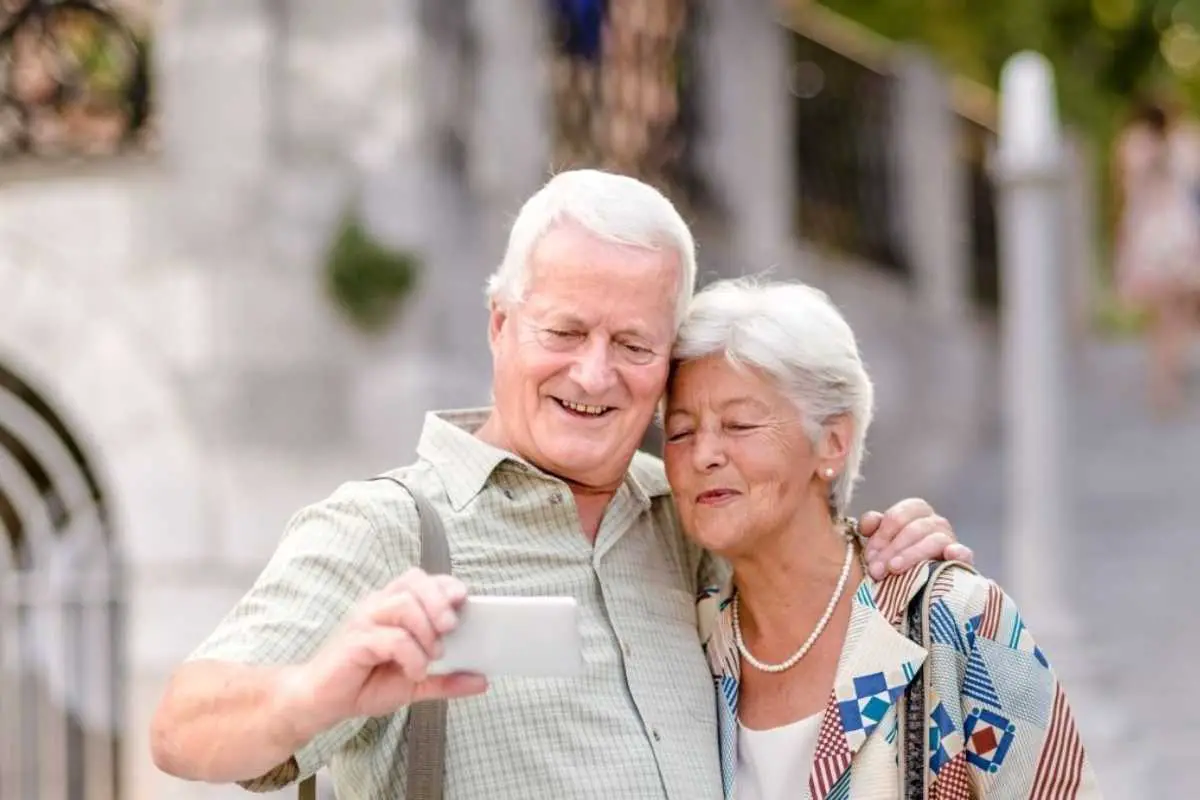 mature selfies - a seniors guide to the perfect selfie feature image of an older couple smiling while taking a selfie in natural light