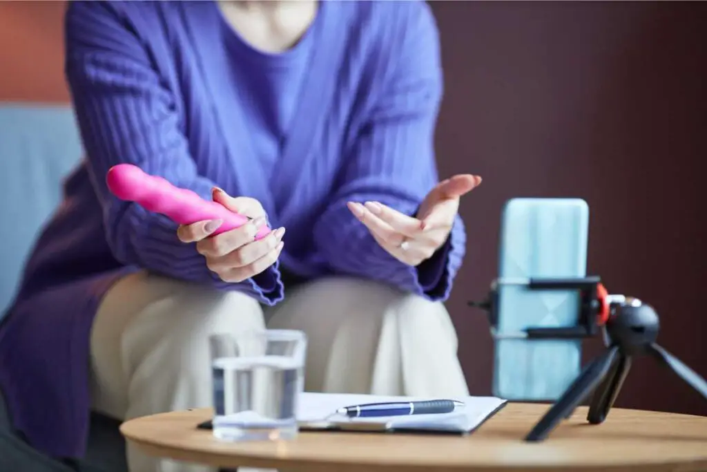 a healthcare provider discussing sexual behavior and sexual relationships in older patients on a video call, while holding a sex toy to increase sexual desire in partners