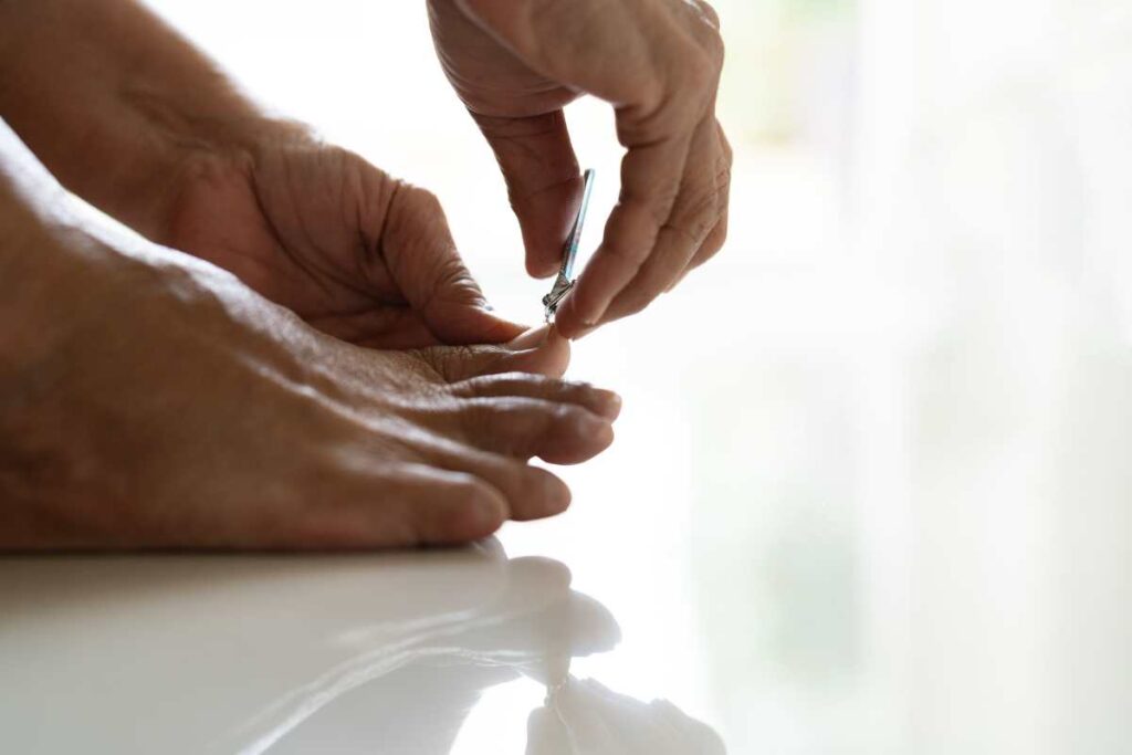 a close up of a person using nail clippers to trim nails straight and avoid rough edges