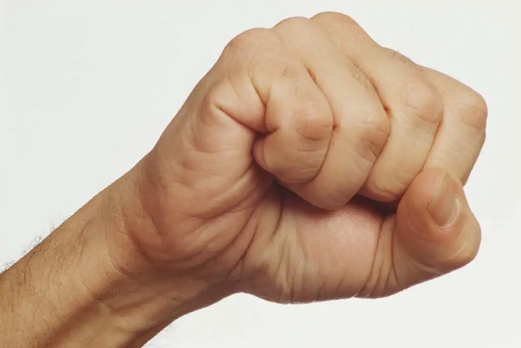 a fist with healthy, thick nails and no visible fungal infections