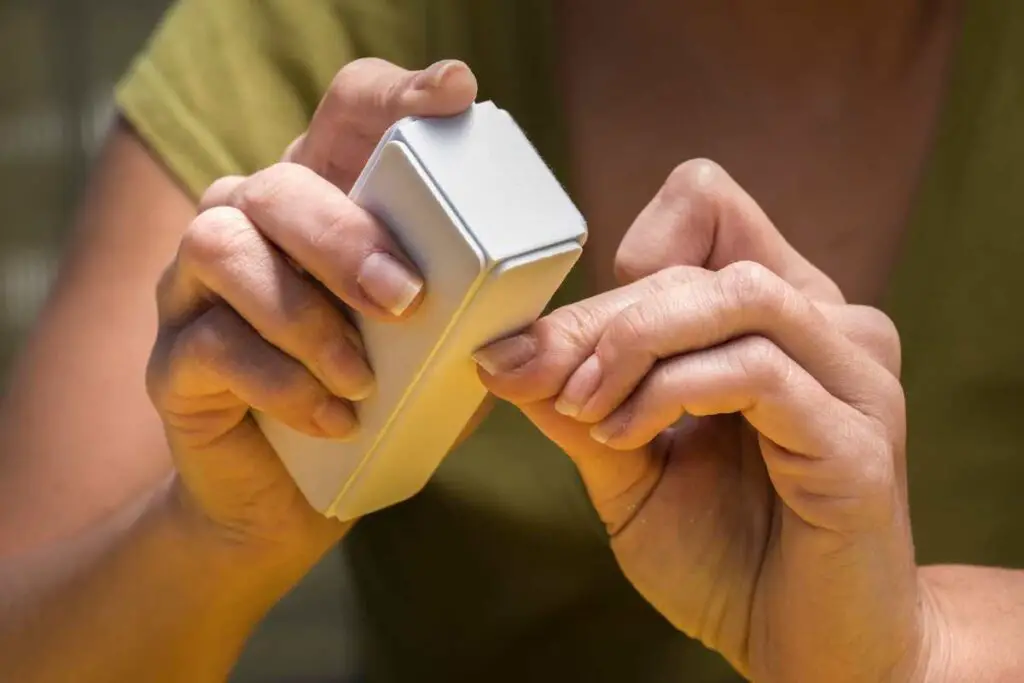 a woman using  a buffing tool to support healthy nails and get rid of dead skin cells around the nail bed