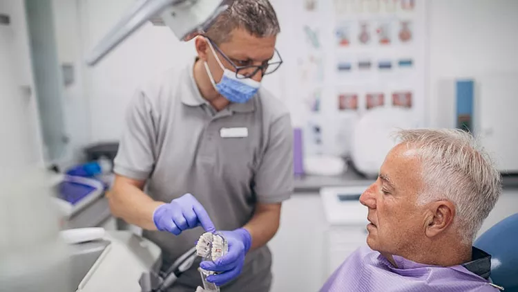 senior patient looking at dentures