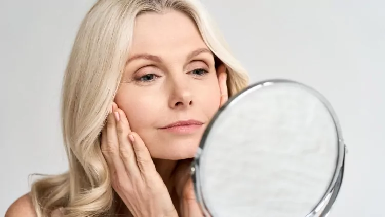 woman looking at mirror after skin tightening treatment